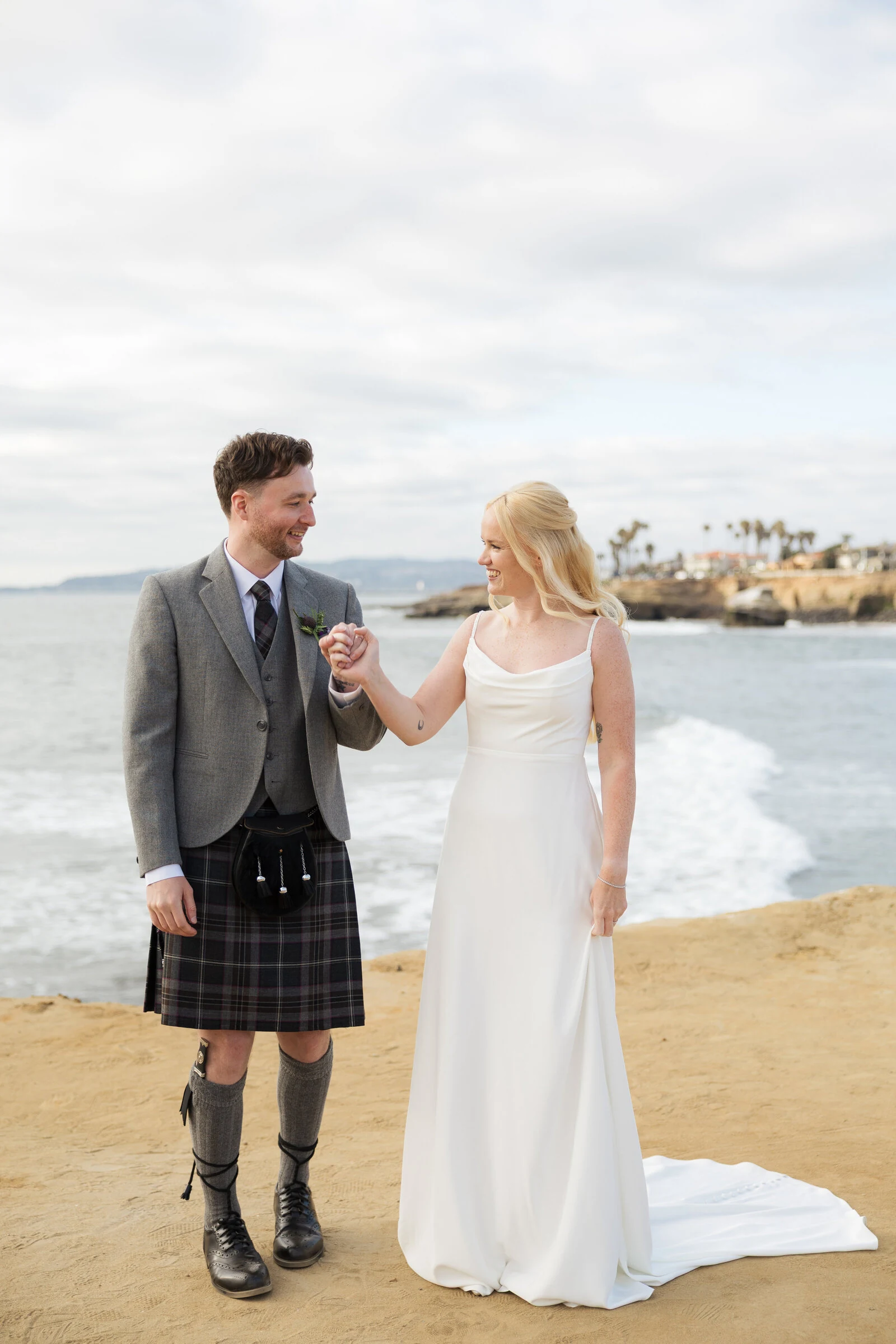 Couple smiles at each other after elopement ceremony at Sunset Cliffs in San Diego