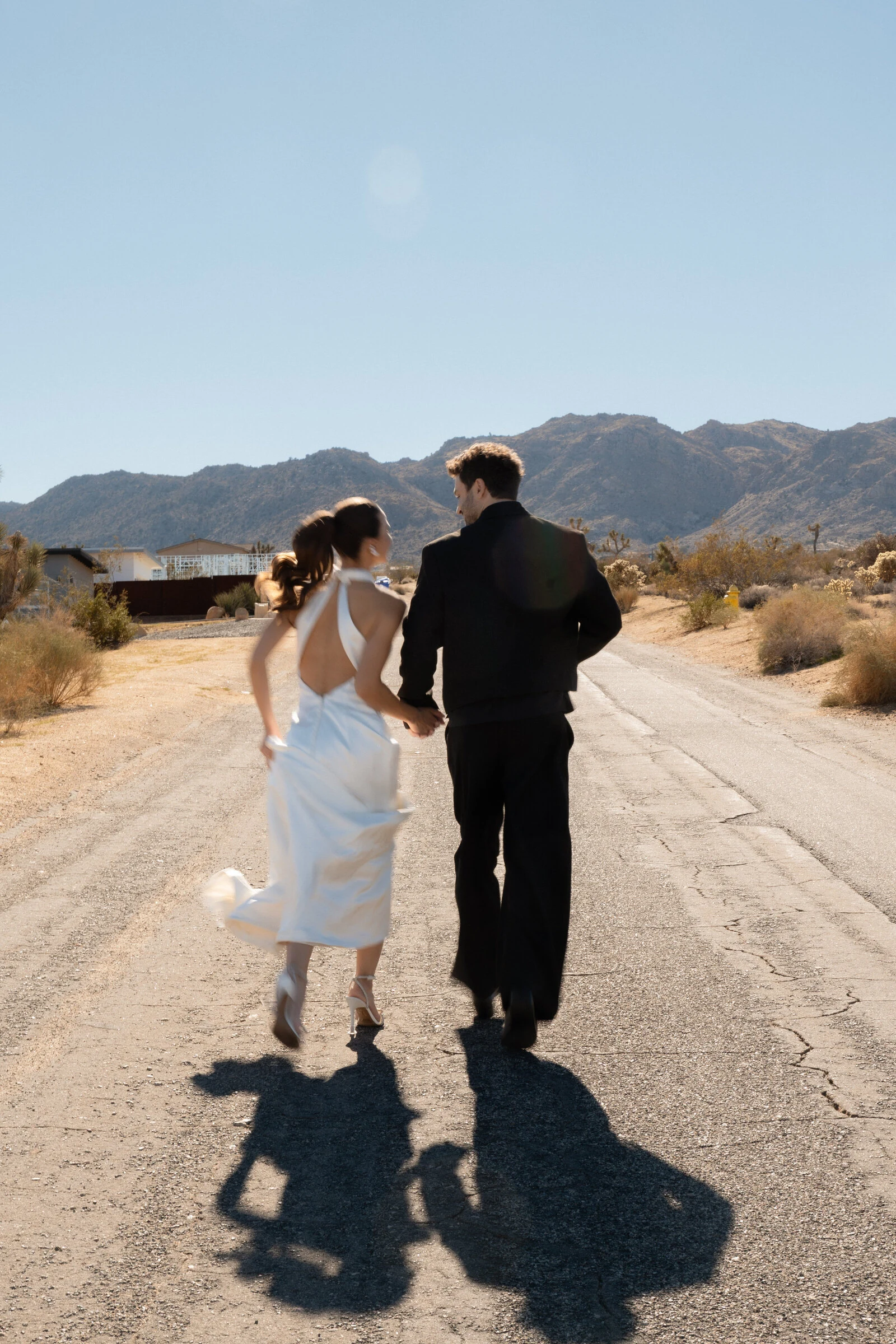 Couple running down the road after eloping in Joshua Tree