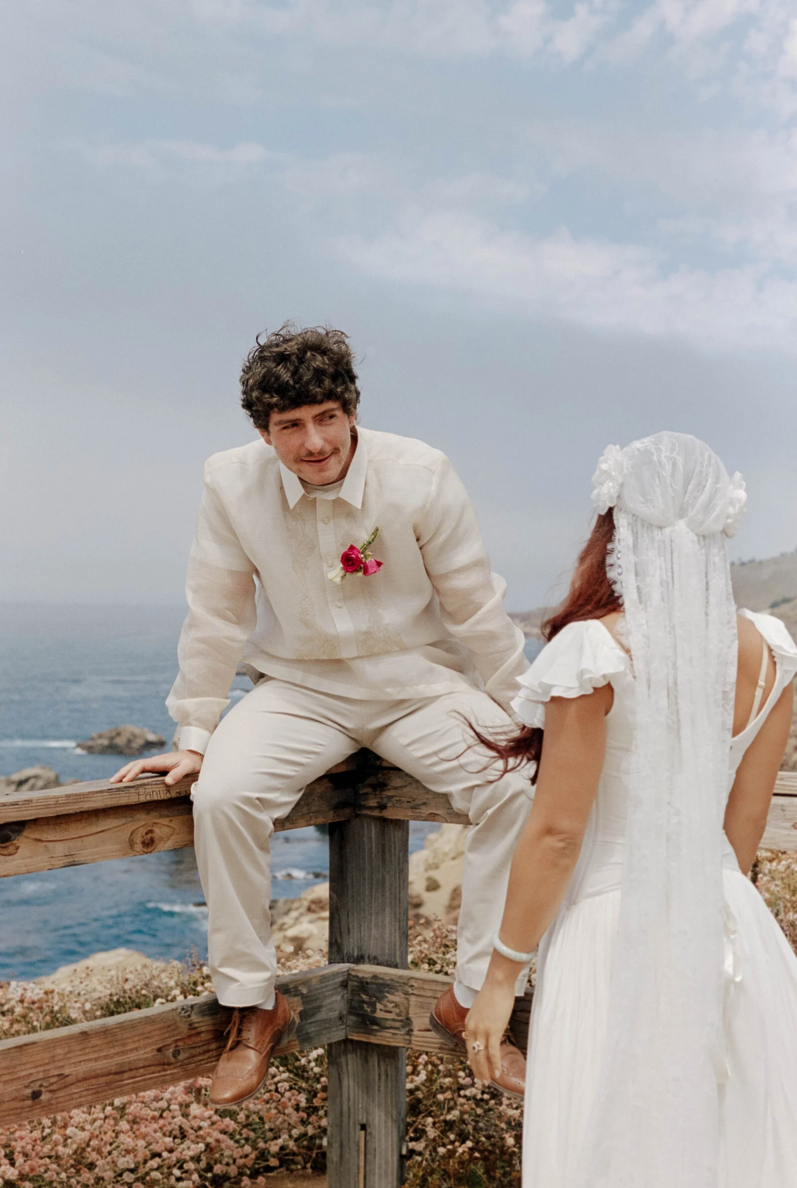 A couple laughing together on their wedding day, photographed on film