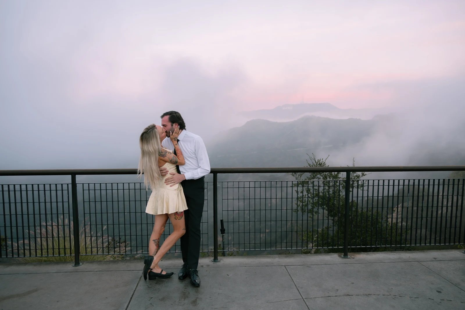 Couple kissing in front of the Hollywood sign in LA