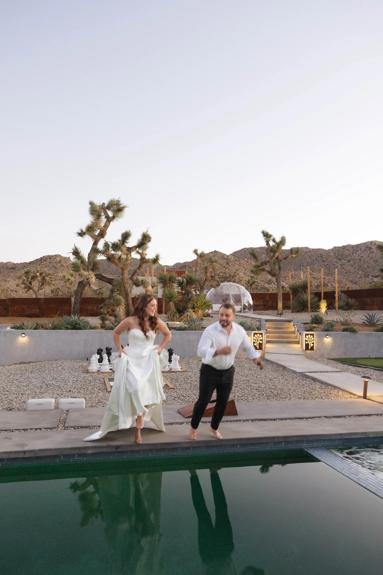 Couple jumping into a pool after their wedding in Joshua Tree