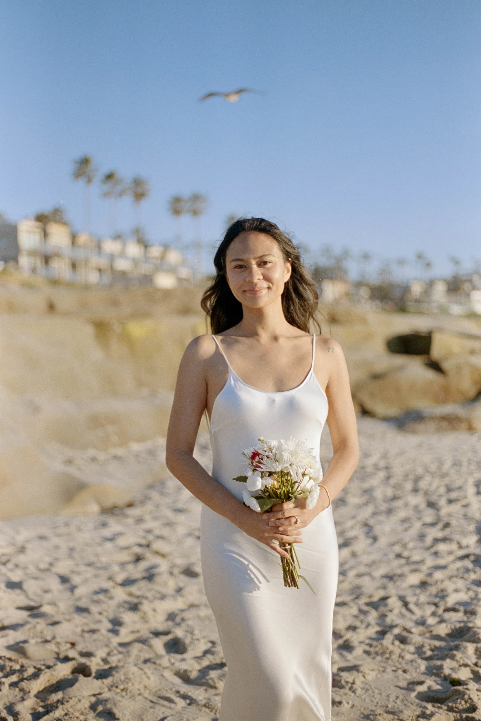 Bride smiling on the beach in San Diego during elopement